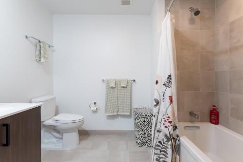 a white bathroom with a toilet and a shower at High Rise Retreat w City Skyline Views Shared Gym in Cambridge