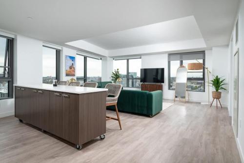a living room with a green couch and a tv at Central Serene Penthouse w King bed GYM Parking in Cambridge