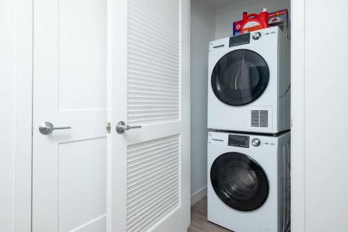 a microwave and a washer and dryer in a room at Central Serene Penthouse w King bed GYM Parking in Cambridge