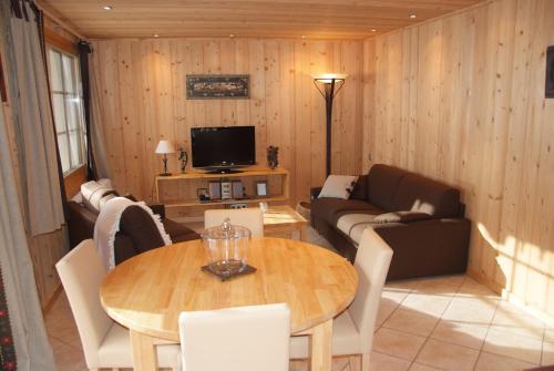 een woonkamer met een tafel en een bank bij gentiane in Les Gets