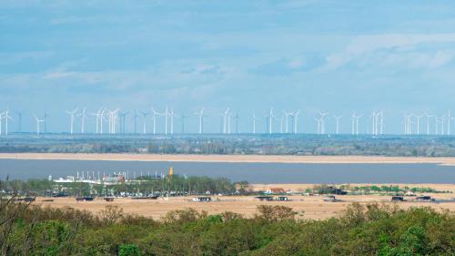 a group of windmills in a field with a body of water at Villa Lilith Smart in Fertőrákos