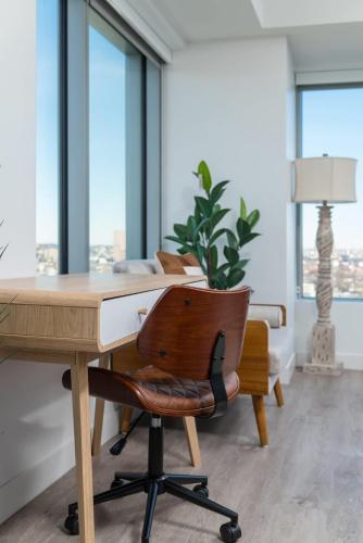 an office with a desk and a chair and windows at Central Serene Penthouse w King bed GYM Parking in Cambridge