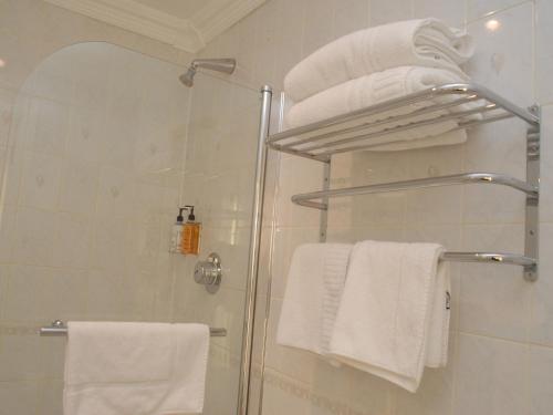 
a white towel hanging on a rack in a bathroom at Gatwick Cambridge Hotel in Horley
