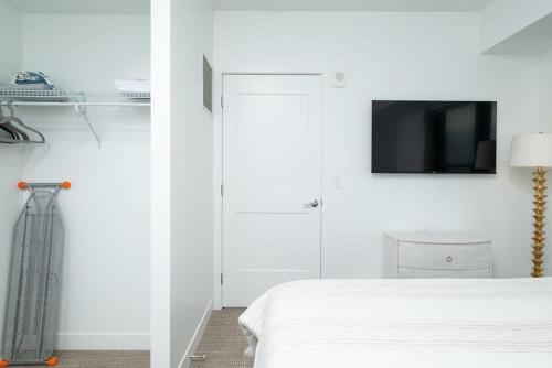 a bedroom with a bed and a tv on a wall at Central Square Penthouse near MIT Harvard Wi-Fi & GYM in Cambridge