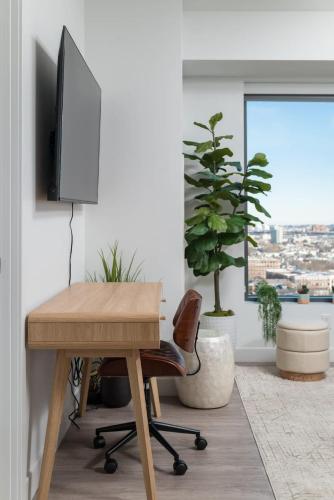 a desk with a television and a chair in a room at Upscale Penthouse near MIT Harvard Central Square in Cambridge