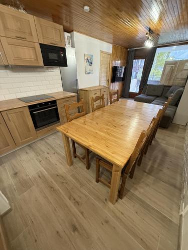 une cuisine et une salle à manger avec une table et des chaises en bois dans l'établissement Appartement Tignes 2100 - 6-8 personnes - 2 chambres - 3 Télévisions - Netflix & Wifi inclus, à Tignes