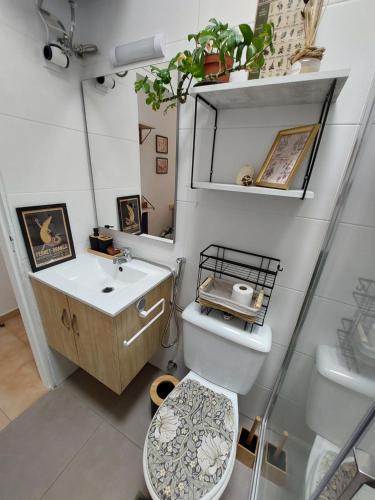 a bathroom with a toilet and a sink at Buenas Flores Tenerife in Costa Del Silencio