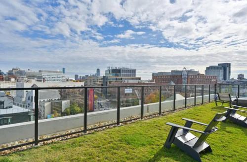 two benches sitting on a balcony with a view of a city at Central Penthouse Harvard MIT Spacious Gym & Work in Cambridge