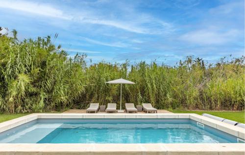 una piscina con sillas y sombrilla en Awesome Home In Serignan, en Sérignan