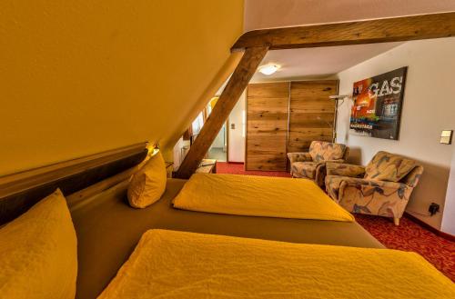 a hotel room with two beds and a chair at Hotel Sonneneck Titisee -Adults Only- in Titisee-Neustadt
