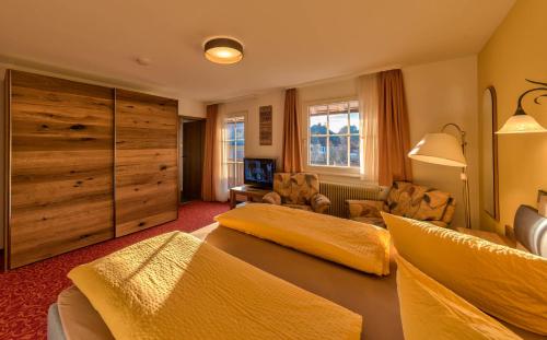 a bedroom with two beds and a living room at Hotel Sonneneck Titisee -Adults Only- in Titisee-Neustadt
