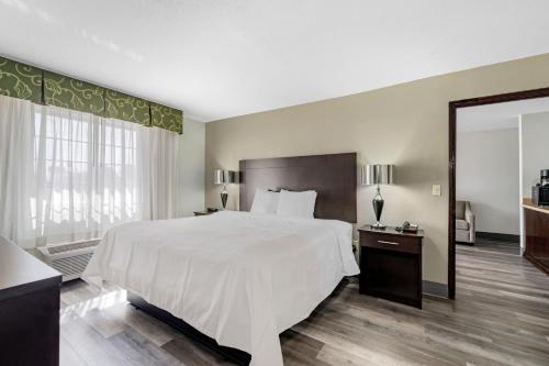a bedroom with a large white bed and a large window at Quality Inn Siloam Springs West in Siloam Springs
