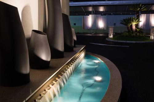 Hotel Lei في فوناباشي: مسبح في غرفة بها مزهريات