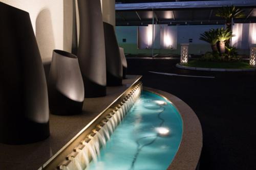 a swimming pool in a room with vases at Hotel Lei in Funabashi