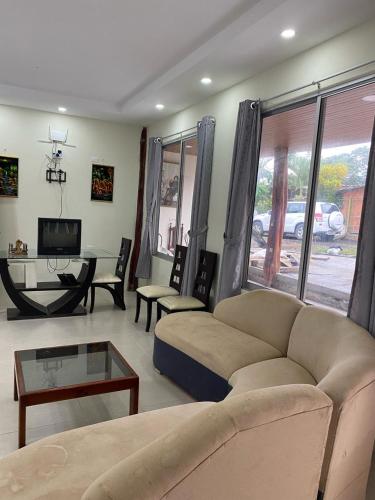 a living room with a couch and a table at CASA BLANCA HORTENCIA in Sucúa