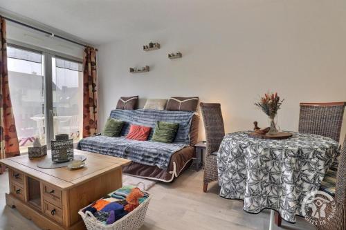 a living room with a couch and a table at Le sens de breizh in Sens-de-Bretagne
