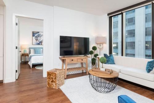 a living room with a white couch and a tv at Back-Bay Upscale Central Condo Bos Common Downtown in Boston