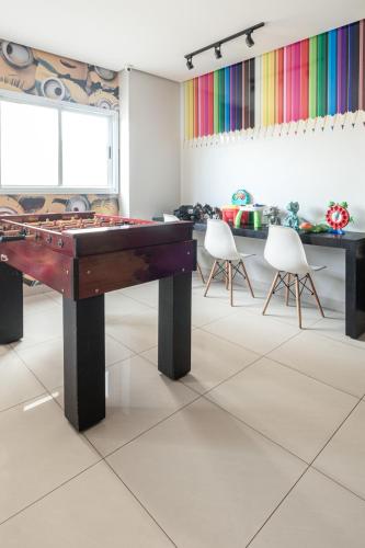 a room with a pool table and two chairs at PALMAS EXPERIENCE - APARTAMENTO CONTEMPORÂNEO, vista serra, na quadra do shopping in Palmas