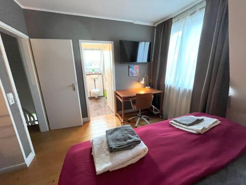 a bedroom with a purple bed with towels on it at Doppelzimmer, eigenes Bad, stadtnahe, ruhig, Airport nahe! in Bönningstedt
