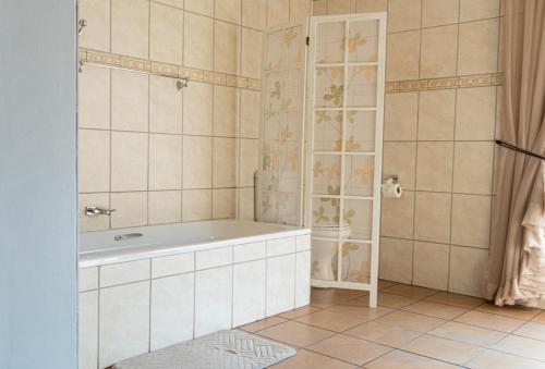 a bathroom with a tub and a shower at Barberton BnB in Barberton