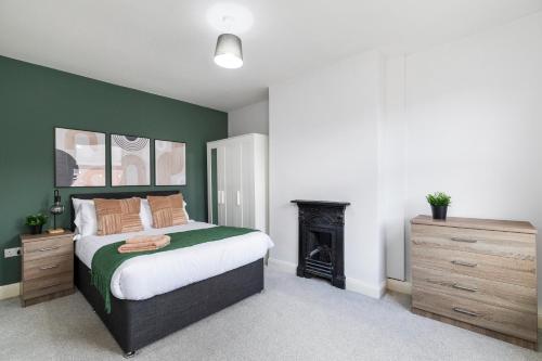a bedroom with a large bed and a fireplace at Spacious Two Bed House in Headingley in Headingley