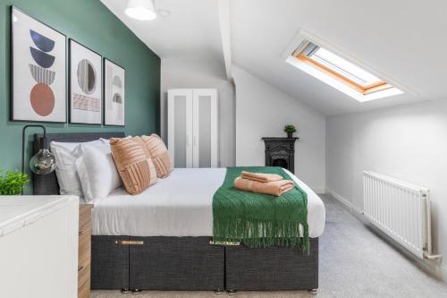 a bedroom with a bed with a green accent wall at Spacious Two Bed House in Headingley in Headingley