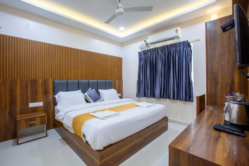 a bedroom with a large bed and a television at Sruthi Residency in Rāmeswaram
