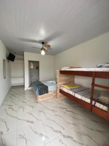 a bedroom with two bunk beds and a ceiling at Pousada Morada do Sol in Caraguatatuba