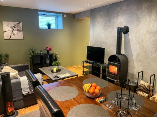 a living room with a table and a wood stove at Two-Bedroom City Apartment with Fire Place, Free Parking and Fjordview Terrace - Calm and Central in Ålesund