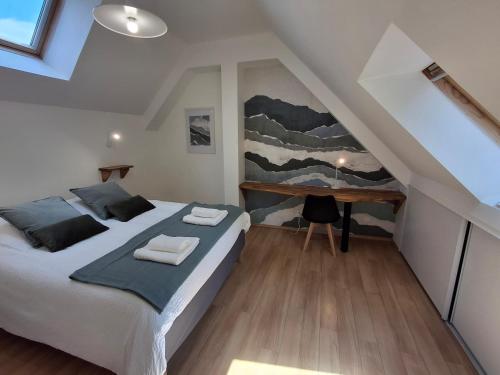 - une chambre mansardée avec un lit et un bureau dans l'établissement Appartement spacieux centre ville parking privé, à Tours