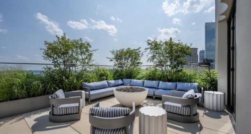 a patio with a blue couch and chairs at Back-Bay 2BR Penthouse w Roof top and GYM in Boston