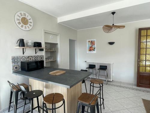 une cuisine avec un comptoir et quelques tabourets dans l'établissement Le Logis de Sally, à La Forêt-sur-Sèvre