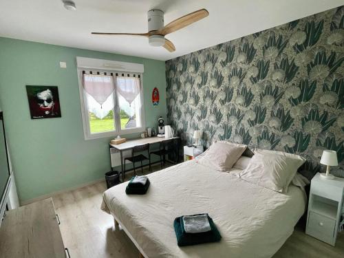 a bedroom with a large bed and a desk at Chambre chez Delphine et Guillaume salle de bain et wc commun in Venarey-les-Laumes