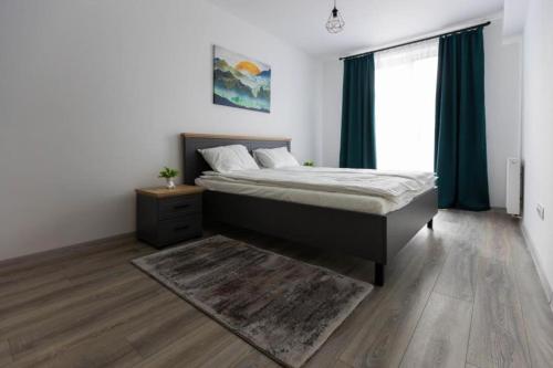 a bedroom with a bed and a large window at Dominic Junior Apartment Sighisoara in Sighişoara