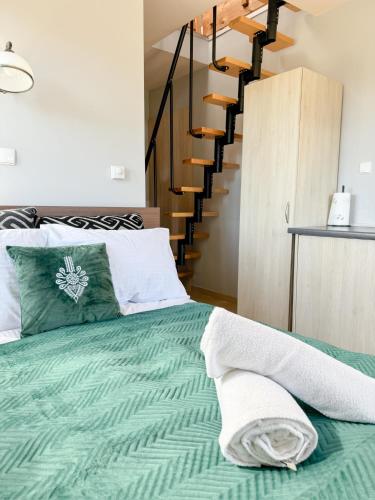 a bedroom with a bed with a green comforter at Willa Chrycówka - Jacuzzi, Basen, Sauna in Kościelisko