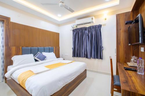 a bedroom with a large bed and a television at Sruthi Residency in Rāmeswaram