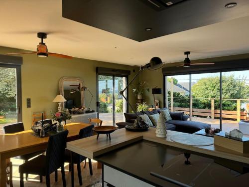 un salon avec un canapé et une table dans l'établissement La Villa de l Observatoire jacuzzi vue mer, à Donville-les-Bains