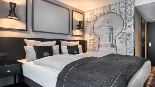 a bedroom with a bed with a picture of a building at Holiday Inn - the niu, Square Mannheim by IHG in Mannheim