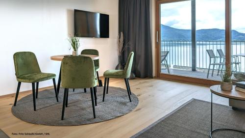 a living room with a table and chairs and a balcony at Seehaus am Kochelsee in Kochel