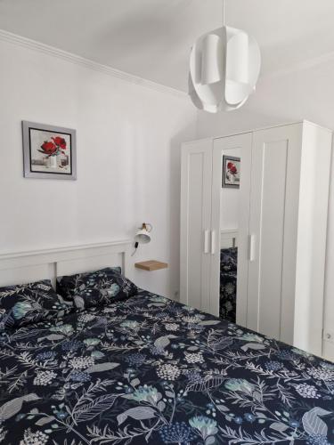 カルカヴェロスにあるVivenda BRANCAのベッドルーム1室(青と白の毛布付きのベッド1台付)