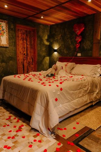 a bedroom with a bed with red hearts on it at CHALÉS LUAR DO PICO in Santo Antônio do Pinhal