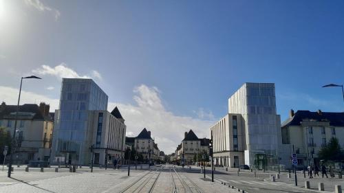 une rue urbaine avec de grands bâtiments dans une ville dans l'établissement Studio indépendant avec jardin, à Saint-Cyr-sur-Loire