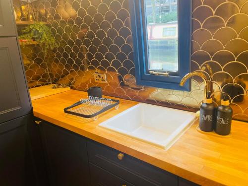 a kitchen counter with a sink and a window at BespokeNarrowBoat in Manchester