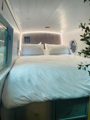 a large bed in the middle of a room at BespokeNarrowBoat in Manchester