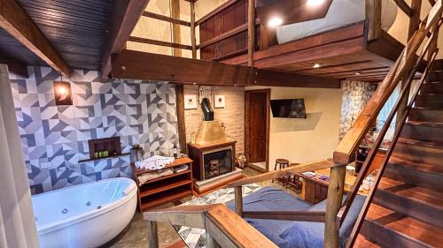 a bathroom with a loft with a tub and a staircase at CHALÉS LUAR DO PICO in Santo Antônio do Pinhal