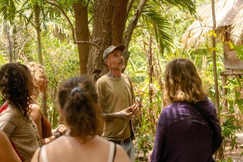 a man talking to a group of people in the jungle at El Zopilote in Balgue