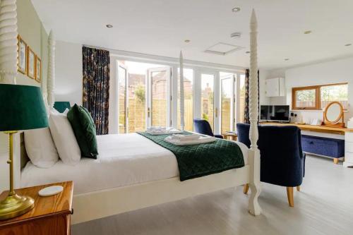 a bedroom with a large bed and a kitchen at Stylish country apartment near Rookery Hall in Worleston