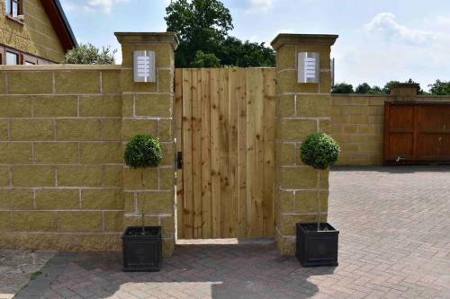 a wooden fence with two potted plants on it at Stylish country apartment near Rookery Hall in Worleston