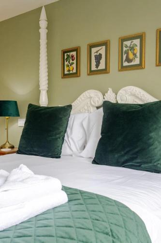 a bed with green and white sheets and pillows at Stylish country apartment near Rookery Hall in Worleston
