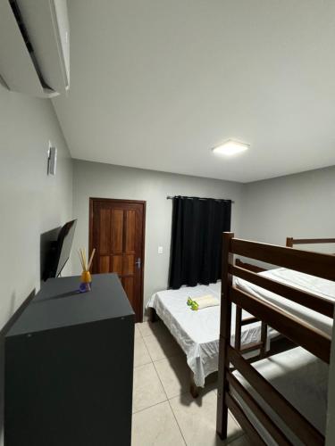 a bedroom with two bunk beds and a desk at Hotel Calleb in Presidente Figueiredo